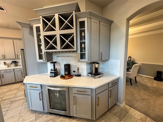 kitchen with wine cooler, light carpet, and gray cabinetry