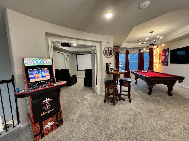 rec room featuring pool table, a textured ceiling, ornamental molding, a raised ceiling, and light colored carpet