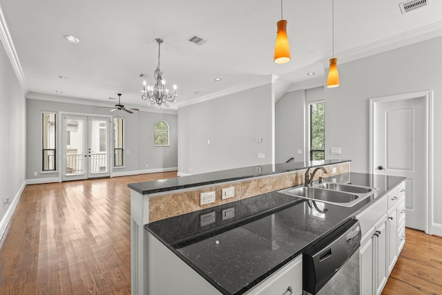 kitchen featuring decorative light fixtures, white cabinetry, dishwasher, sink, and a kitchen island with sink