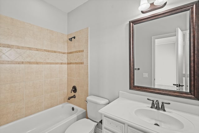 full bathroom featuring tiled shower / bath, vanity, and toilet