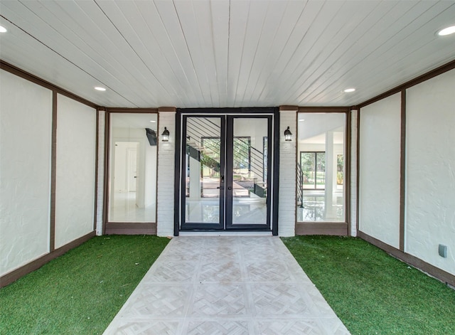 entrance to property featuring french doors and a yard