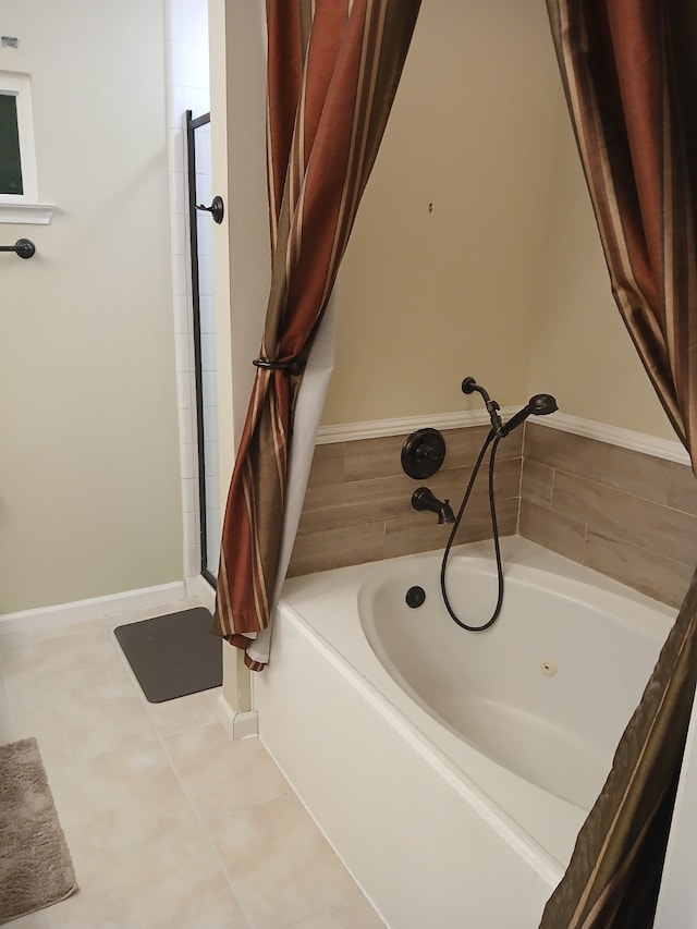 bathroom with tile patterned floors and a tub to relax in