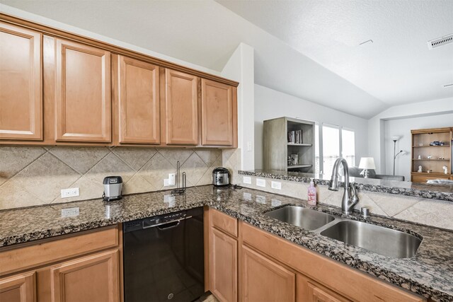 kitchen with lofted ceiling, sink, dark stone countertops, dishwasher, and backsplash