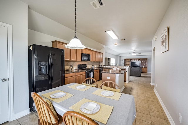 tiled dining area featuring vaulted ceiling and ceiling fan