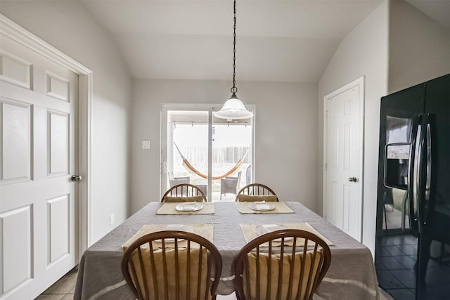 tiled dining room featuring lofted ceiling