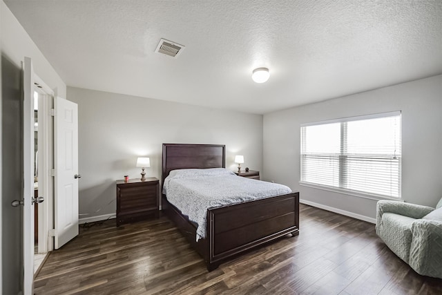 bedroom featuring dark hardwood / wood-style floors and a textured ceiling