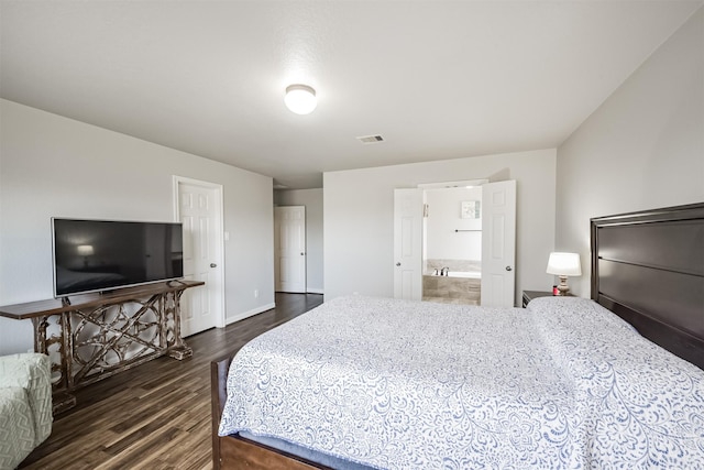 bedroom with dark wood-type flooring and connected bathroom