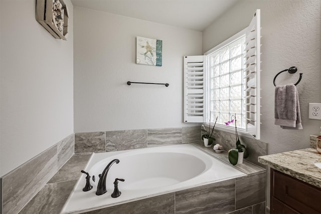 bathroom with a relaxing tiled tub and vanity