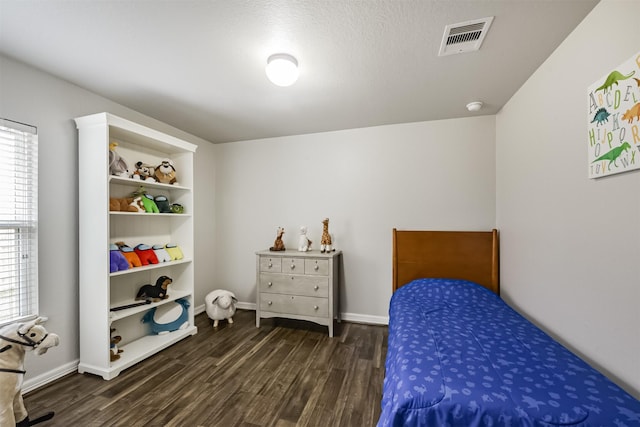 bedroom with dark hardwood / wood-style floors and a textured ceiling