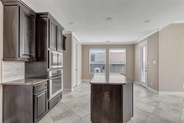 kitchen featuring crown molding, stainless steel appliances, dark brown cabinetry, a kitchen island, and decorative backsplash