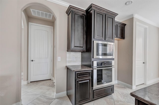 kitchen featuring stainless steel appliances, crown molding, tasteful backsplash, and dark brown cabinetry