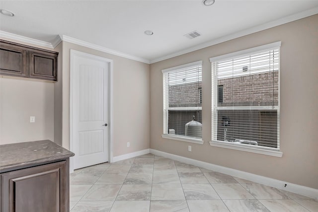 unfurnished dining area featuring crown molding