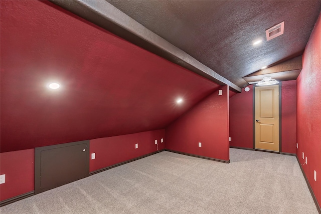 additional living space with lofted ceiling, light carpet, and a textured ceiling