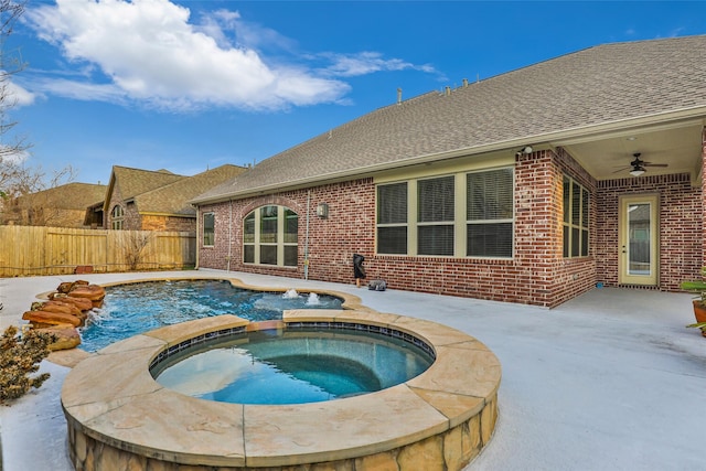 view of pool with an in ground hot tub, pool water feature, ceiling fan, and a patio