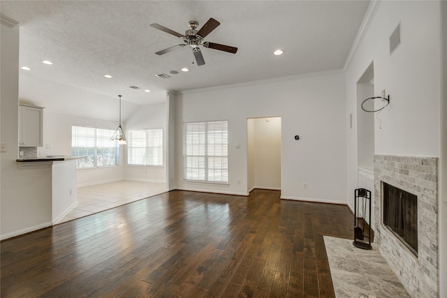 unfurnished living room featuring crown molding, wood-type flooring, ceiling fan with notable chandelier, and a textured ceiling