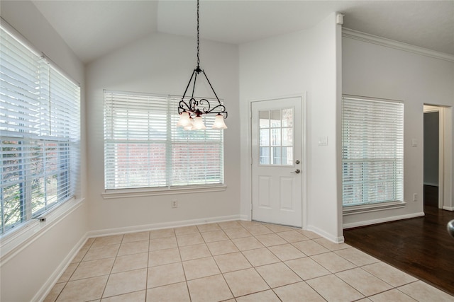 unfurnished dining area with light tile patterned flooring, a chandelier, and vaulted ceiling