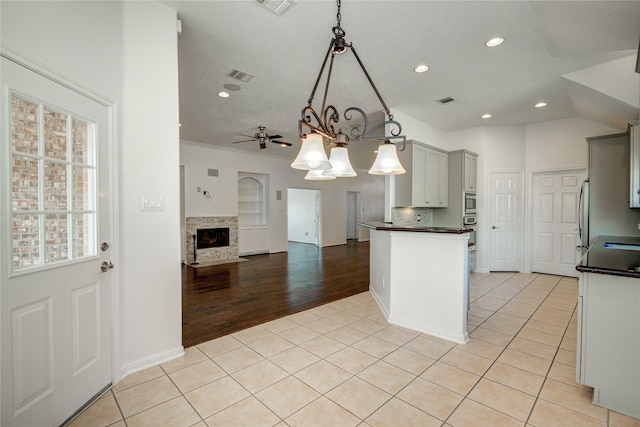 kitchen featuring backsplash, decorative light fixtures, gray cabinets, and light tile patterned floors