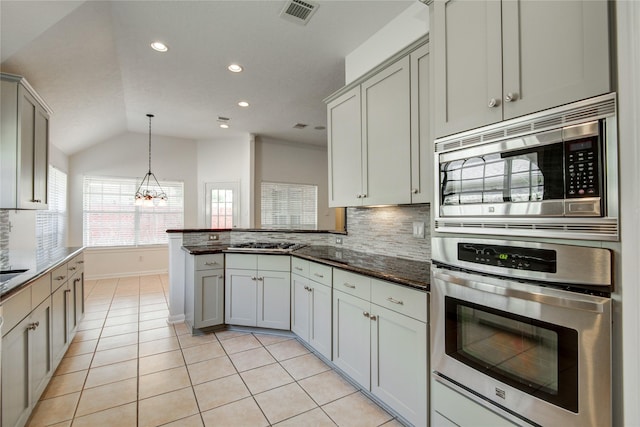 kitchen with gray cabinetry, hanging light fixtures, backsplash, stainless steel appliances, and kitchen peninsula