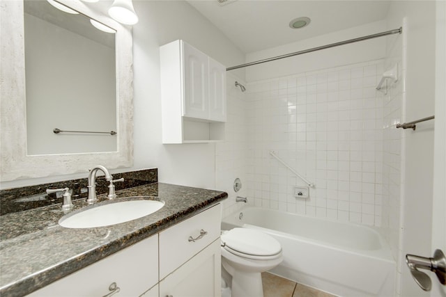 full bathroom featuring vanity, toilet, tiled shower / bath combo, and tile patterned flooring