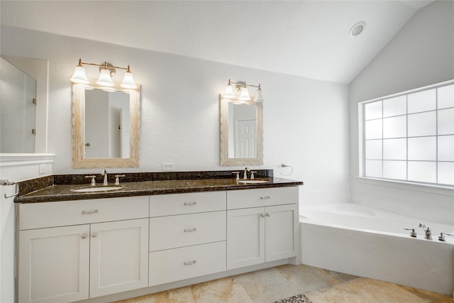 bathroom featuring a washtub, vanity, and lofted ceiling