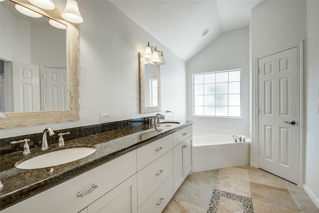 bathroom with lofted ceiling, vanity, and a bathtub