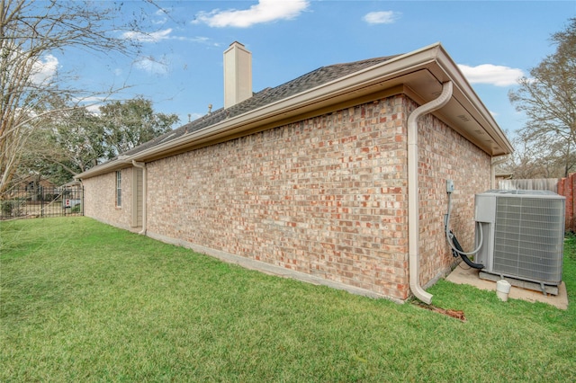 view of side of property with central AC unit and a lawn