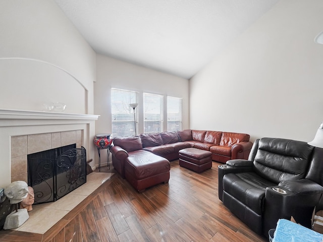 living room with hardwood / wood-style flooring, a fireplace, and vaulted ceiling