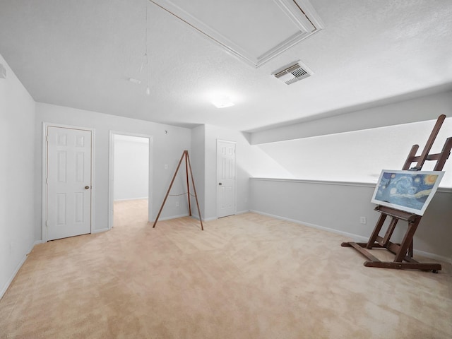 bonus room featuring light carpet and a textured ceiling