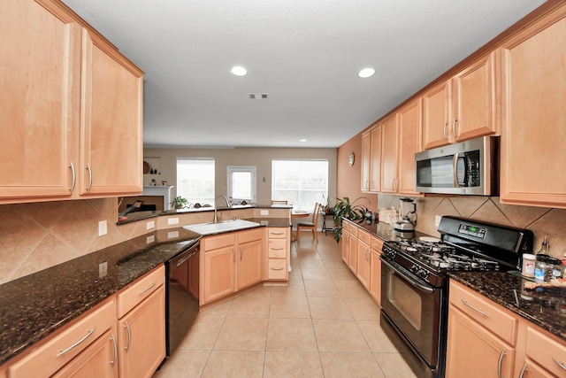 kitchen featuring sink, light brown cabinets, and black appliances