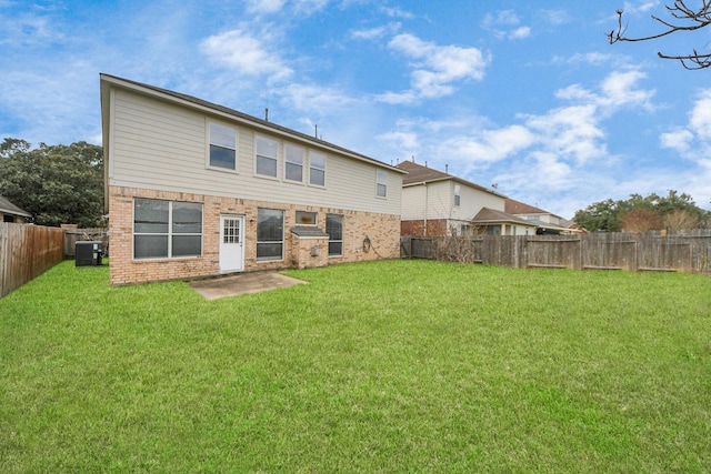 rear view of property with cooling unit, a yard, and a patio area