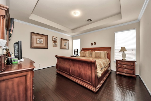 bedroom featuring dark hardwood / wood-style flooring, crown molding, and a raised ceiling