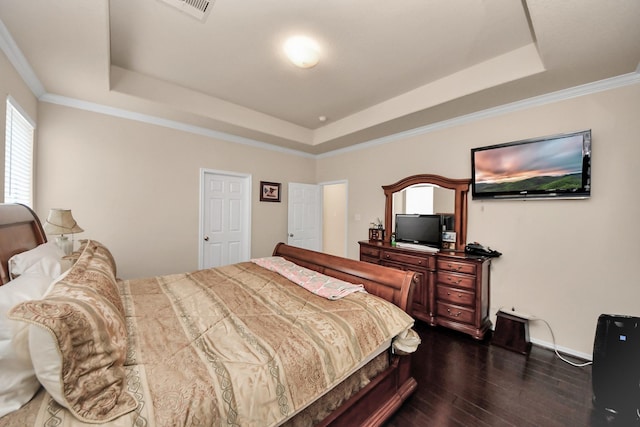 bedroom with ornamental molding, dark hardwood / wood-style floors, and a raised ceiling