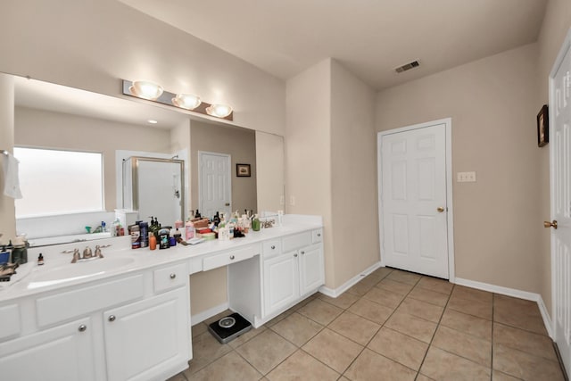 bathroom featuring vanity, a shower with door, and tile patterned flooring