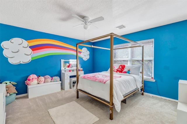 bedroom with ceiling fan, carpet floors, and a textured ceiling