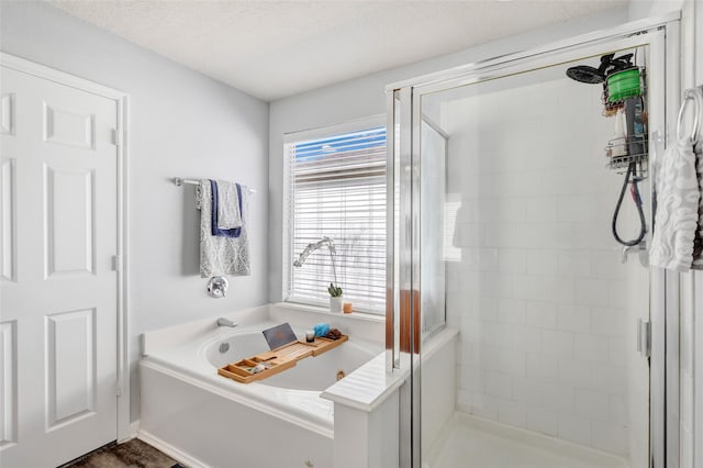 bathroom featuring independent shower and bath and a textured ceiling