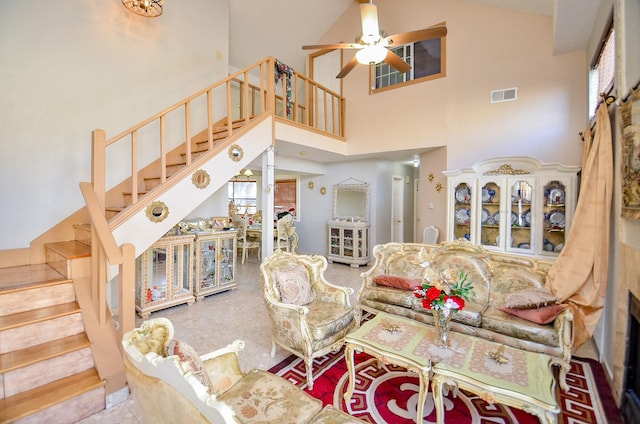 living room with ceiling fan and a high ceiling