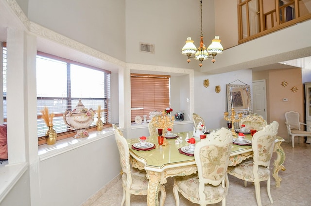 dining area featuring an inviting chandelier and a high ceiling