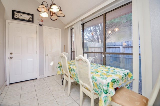 dining area featuring light tile patterned flooring, lofted ceiling, and a chandelier