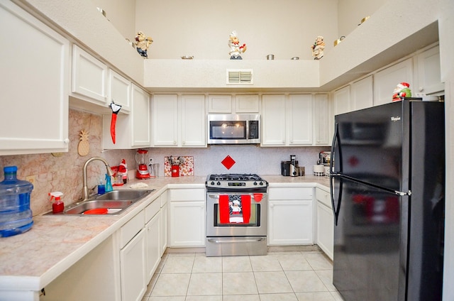 kitchen featuring white cabinetry, appliances with stainless steel finishes, sink, and light tile patterned flooring