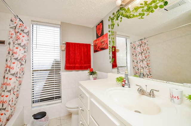 full bathroom featuring shower / tub combo with curtain, tile patterned floors, toilet, a textured ceiling, and vanity