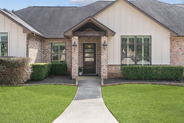 property entrance with roof with shingles, brick siding, and board and batten siding