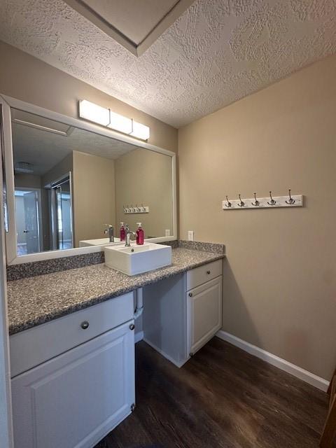 bathroom with vanity, wood-type flooring, and a textured ceiling