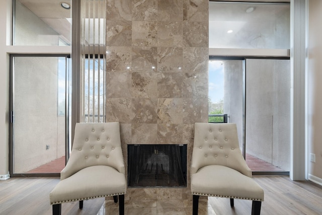 living area featuring hardwood / wood-style flooring and a tile fireplace