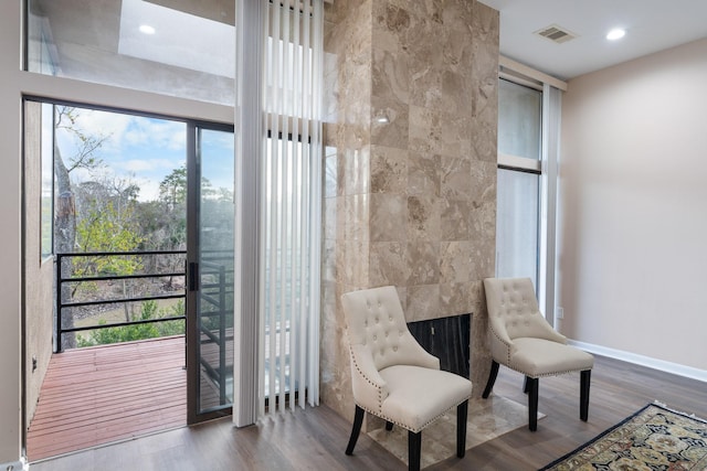 sitting room featuring hardwood / wood-style flooring and tile walls