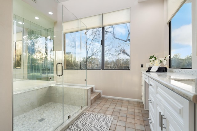 bathroom with an enclosed shower, vanity, tile patterned floors, and a healthy amount of sunlight