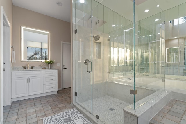 bathroom featuring tile patterned floors, vanity, and shower with separate bathtub