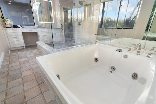 bathroom featuring vanity, tile patterned floors, and a bathing tub