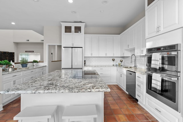 kitchen featuring appliances with stainless steel finishes, a center island, sink, and white cabinets