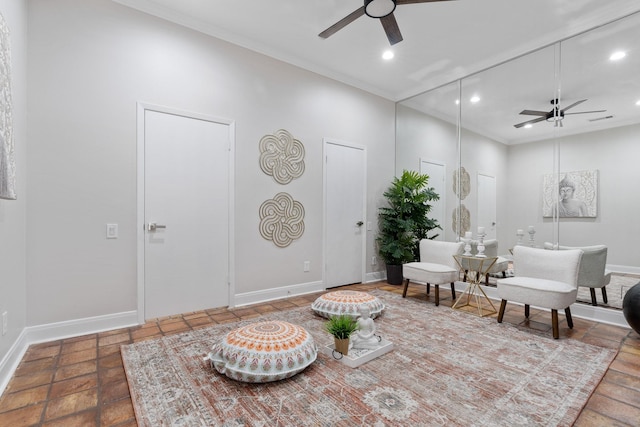 living area with crown molding and ceiling fan