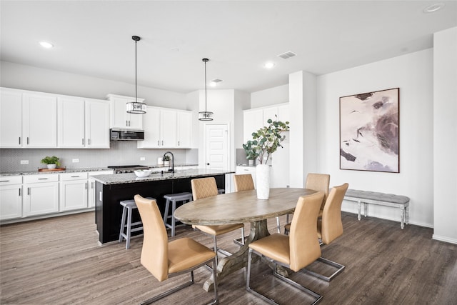 dining space with dark hardwood / wood-style floors and sink